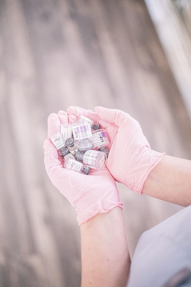 Gloved hands holding vials of injectables