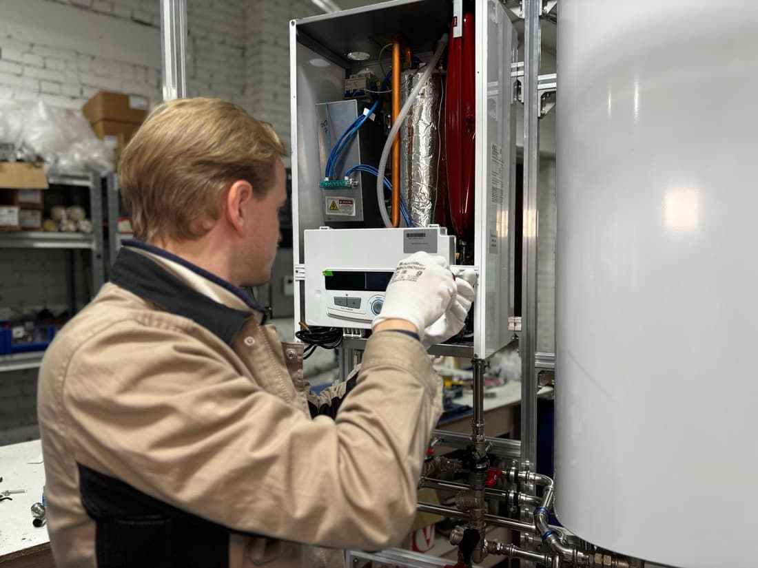 A technician servicing a water heater
